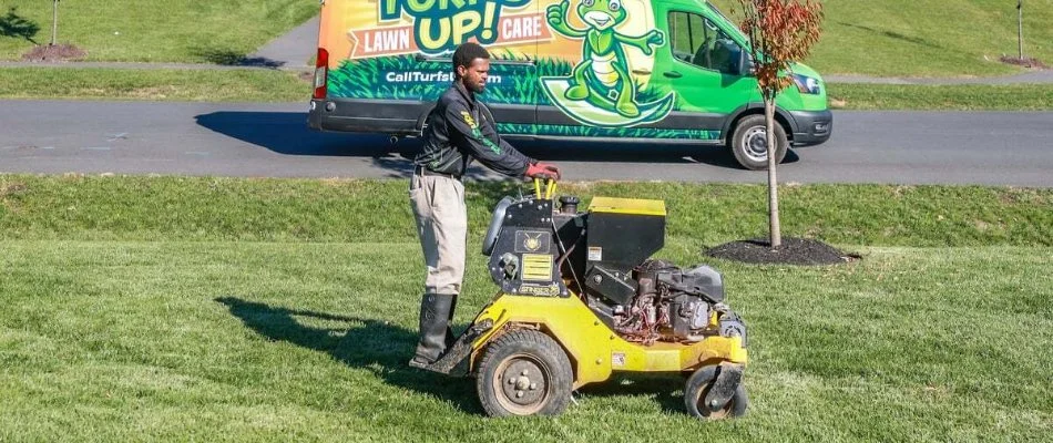 A lawn care professional aerating a lawn in Leesburg, VA.